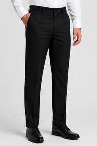 A man wearing black dress pants with a white dress shirt and black leather dress shoes, shown from the waist down against a light gray studio background.